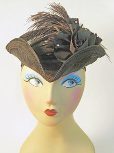 A classic TriCorn Hat in lightweight Sinamay material, this all black hat is decorated with a silk rose and spray of feathers.